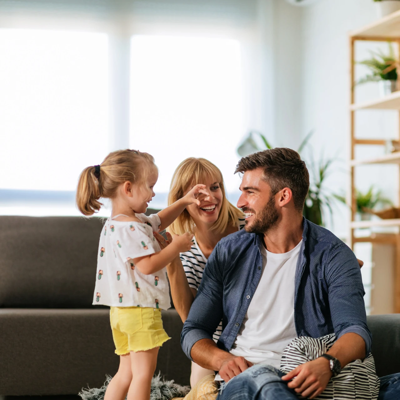 Familie | © KWB, Bernhard Bodo Mutter, Vater, Kind sitzen auf dem Wohnzimmerboden und lachen