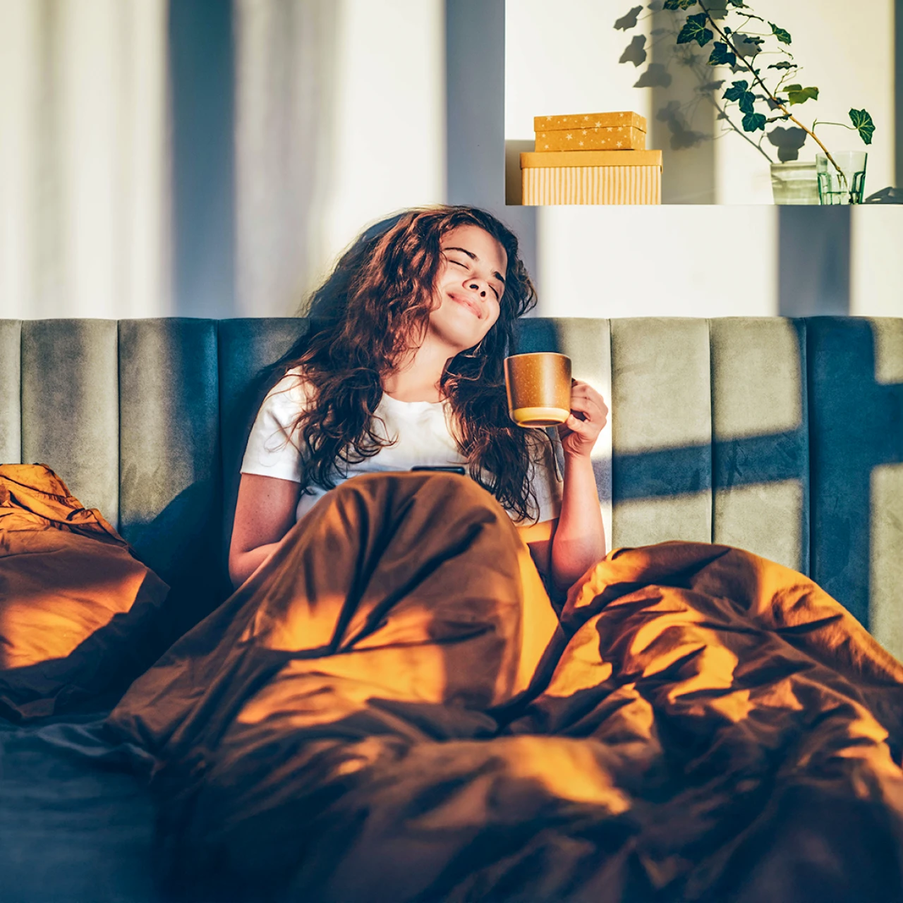 Frau entspannt | © Mariia Korneeva Eine Frau sitzt entspannte mit einer Tasse Kaffee im Bett