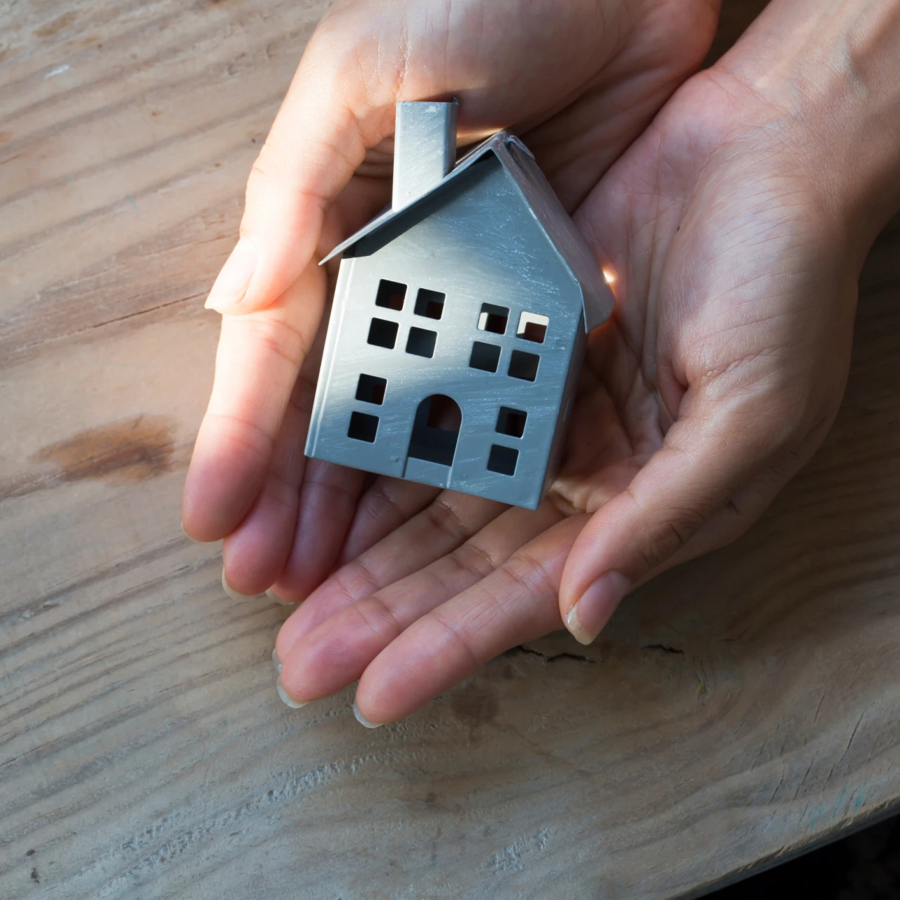 Haus in der Hand | © lucid_dream Eine Person haltet ein kleines Metall Haus in den Haenden