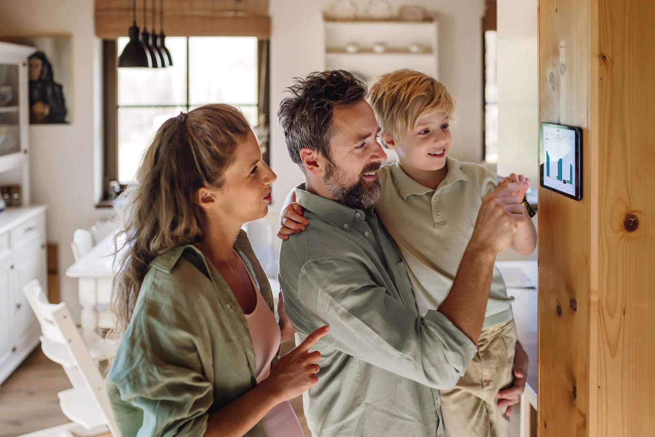 © KWB, Halfpoint Familie bedient gemeinsam ein Tablet an der Wand.