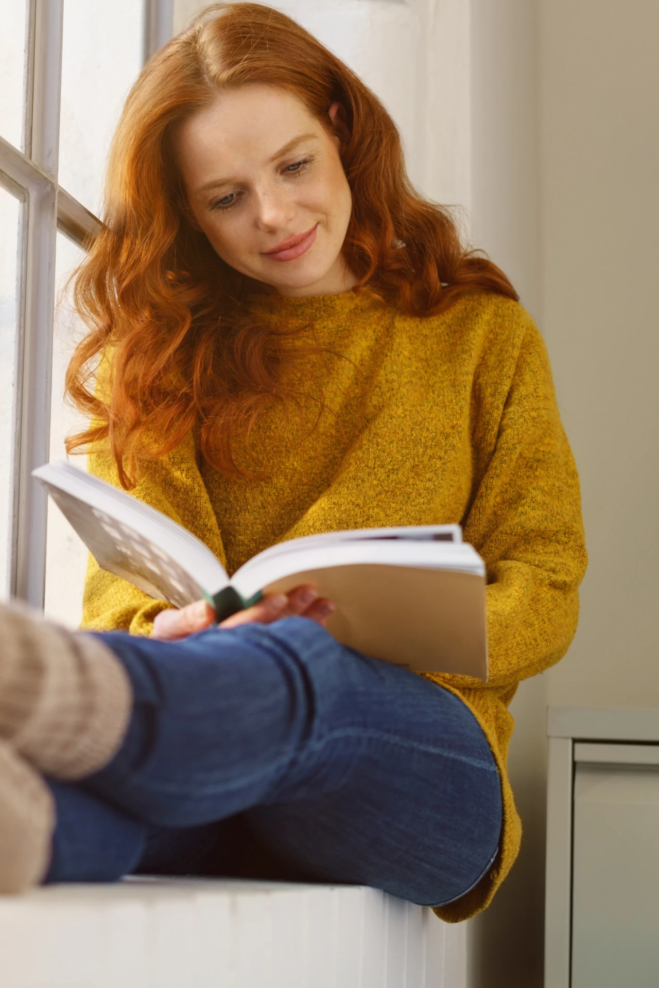 Lesende Frau | © KWB Frau liest ein Buch auf dem Fensterbrett