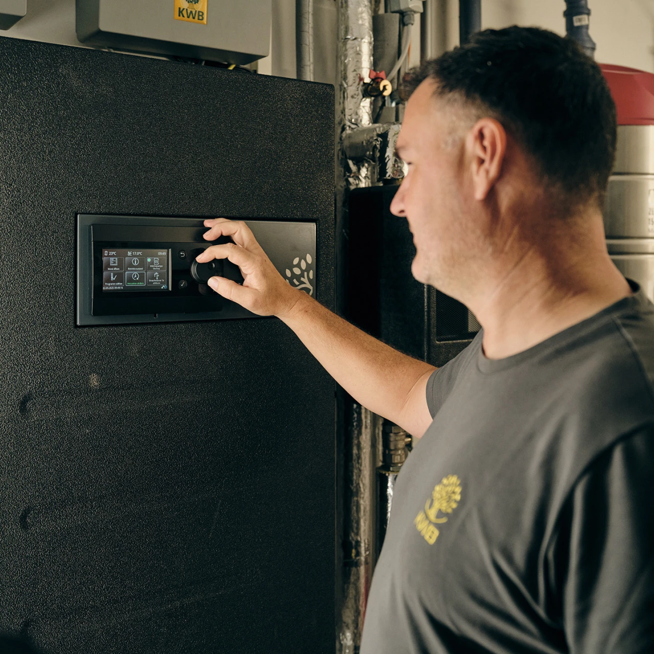 KWB Techniker | © KWB, Raphael Nast Hier sieht man einen KWB Mitarbeiter der bei dem KWB Frischwassermodul was einstellt