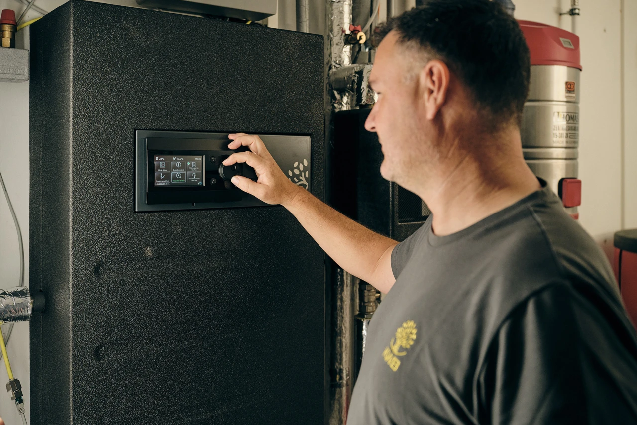 KWB Techniker | © KWB, Raphael Nast Hier sieht man einen KWB Mitarbeiter der bei dem KWB Frischwassermodul was einstellt