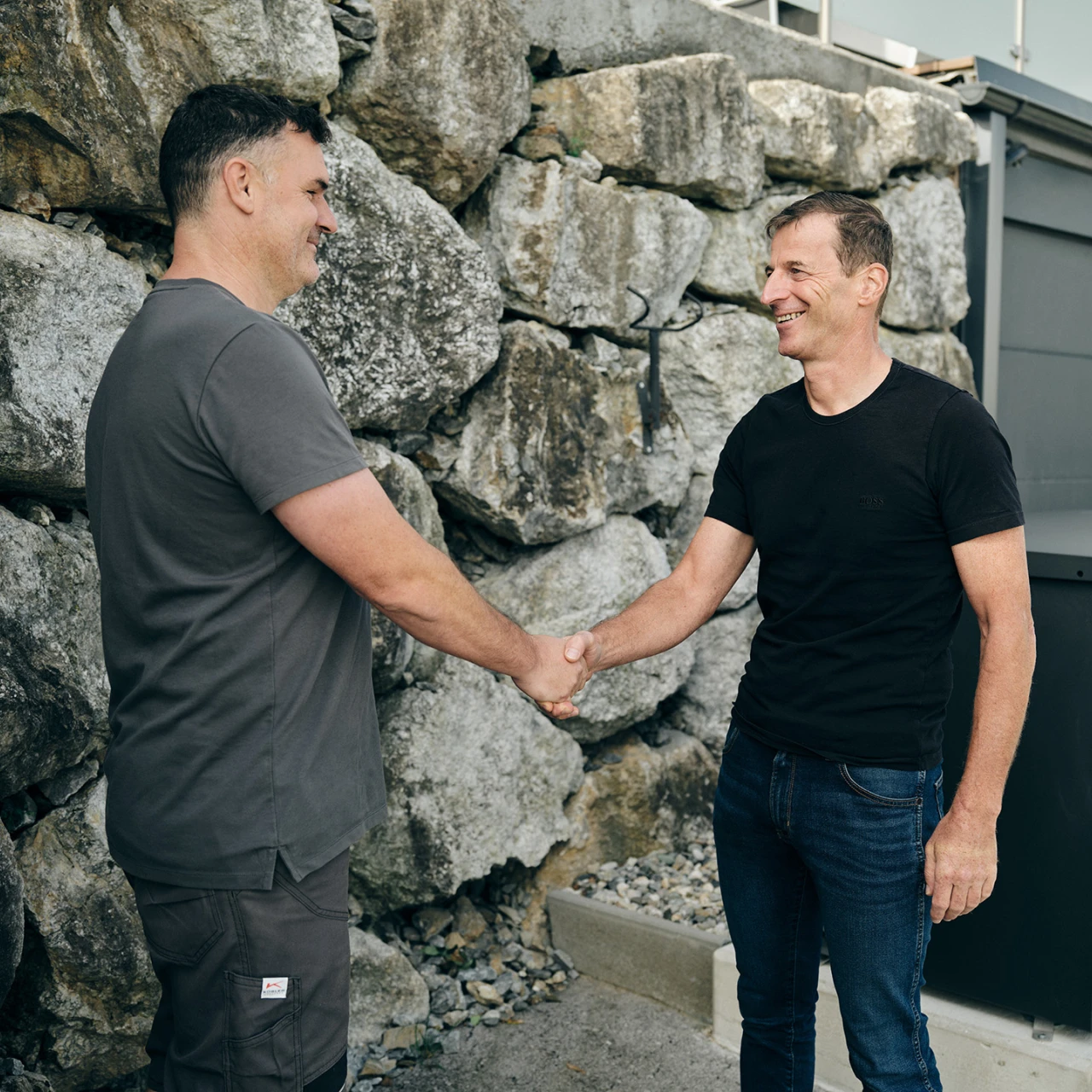 KWB Wärmepumpe EasyAir Plus | © KWB, Raphael Nast Man sieht einen KWB Mitarbeiter der dem Herrn Galler seine Hand reicht und im Hintergrund sieht man die KWB Waermepumpe