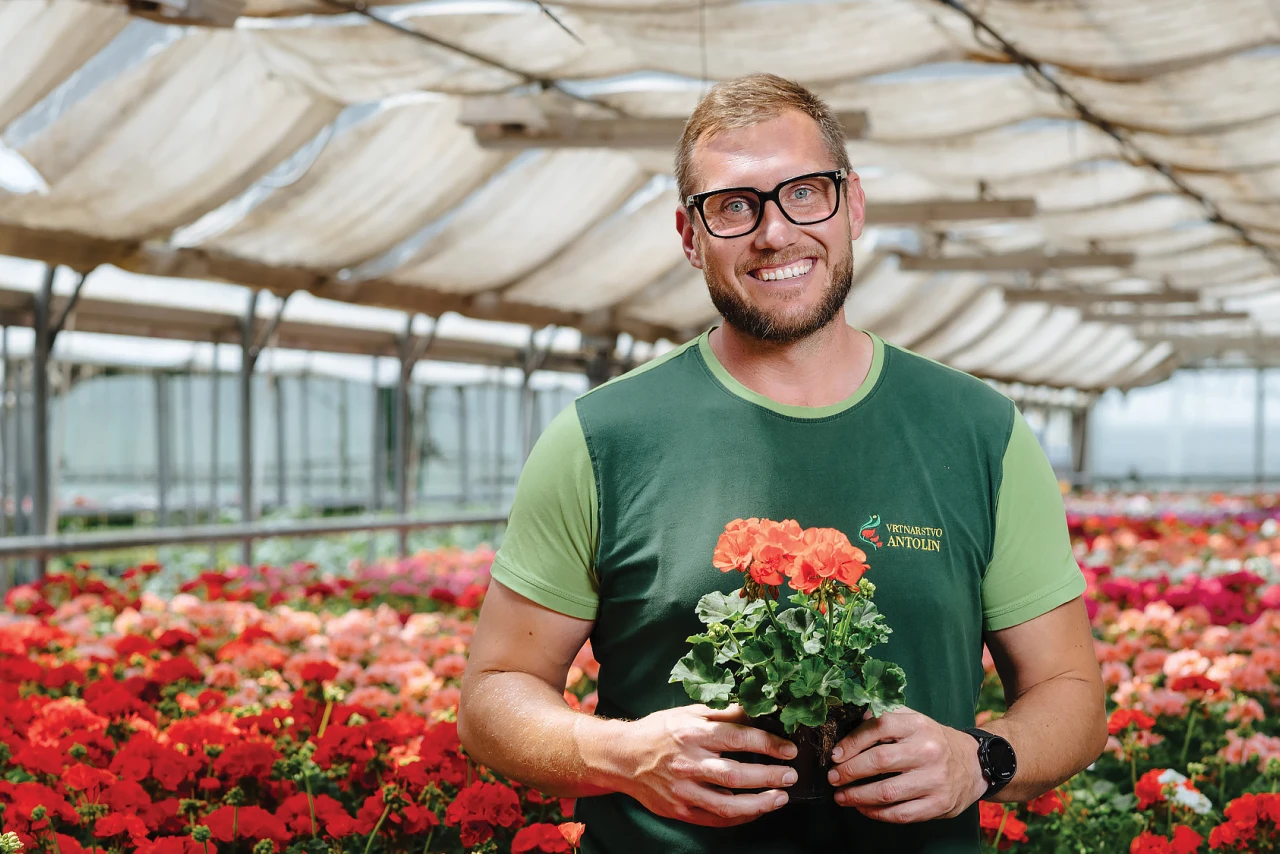 Referenzkunde Antolin blumige wärme | © KWB Man sieht den Herrn Antolin der Blumen in der Hand haelt und in die Kamera lacht