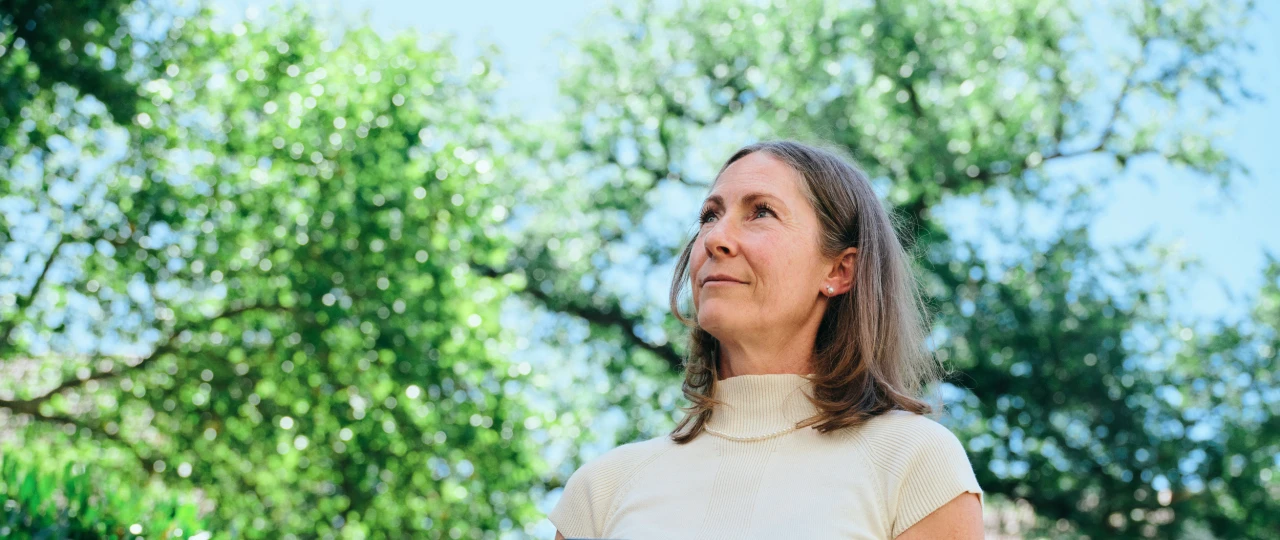 Referenzkunde Antje Krause | © KWB, Raphael Nast Man sieht eine Frau die ein Handy in der Hand haltet und in die Natur sieht