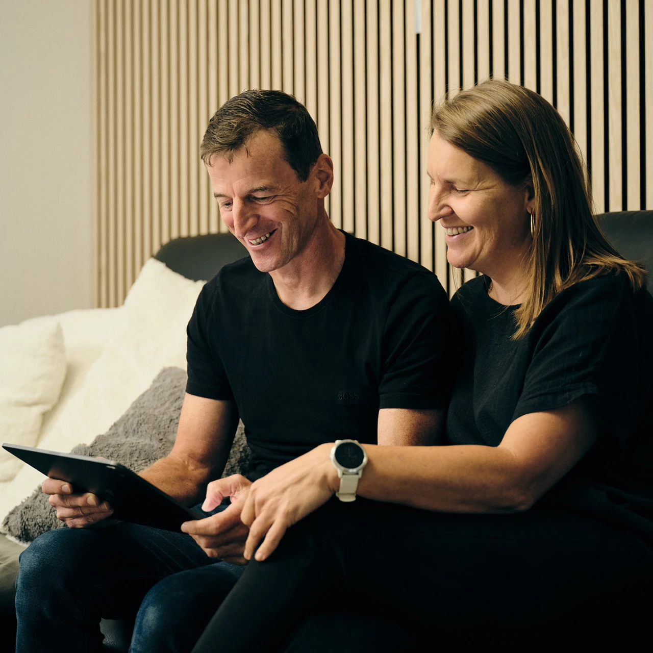 Referenzkunde Familie Galler | © KWB Hier sieht man die Familie Galler die auf dem Sofa sitzen und sich was auf einem Tablet anschauen