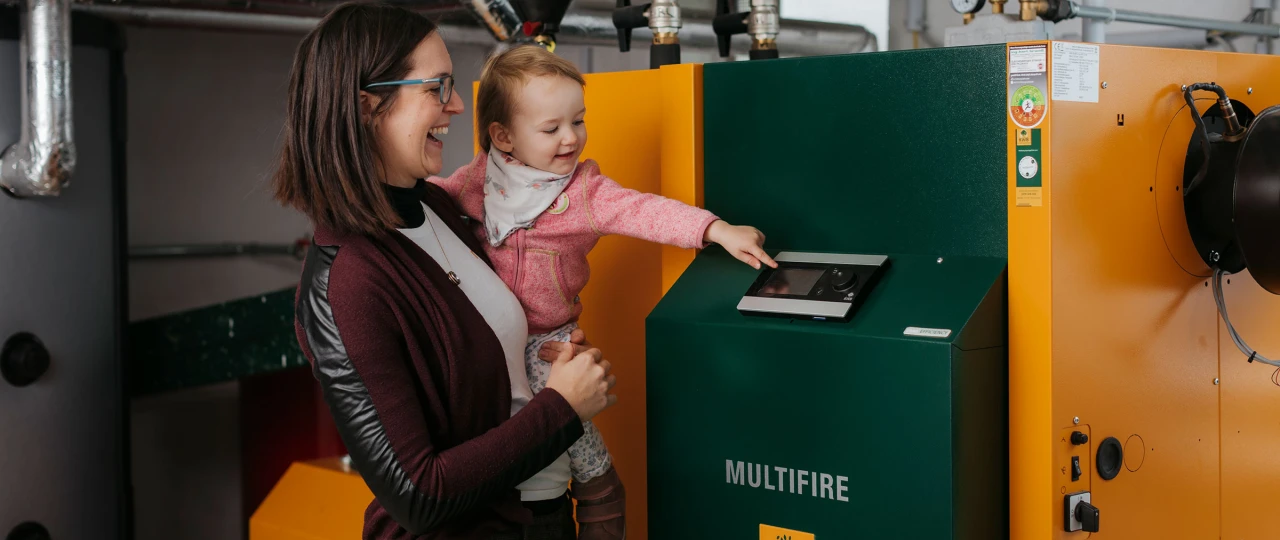 Referenzkunde Familie Prassl | © KWB Hier sieht man die Frau Praßl mit Ihrer Tochter vor dem KWB Multifire Kessel