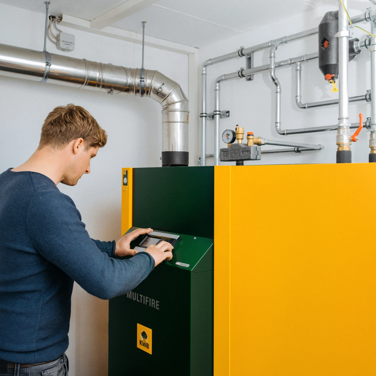 Referenzkunde Gregor Reicher | © KWB, LupiSpuma Hier sieht man Herrn Reicher der vor seinem KWB Multifire Kessel steht