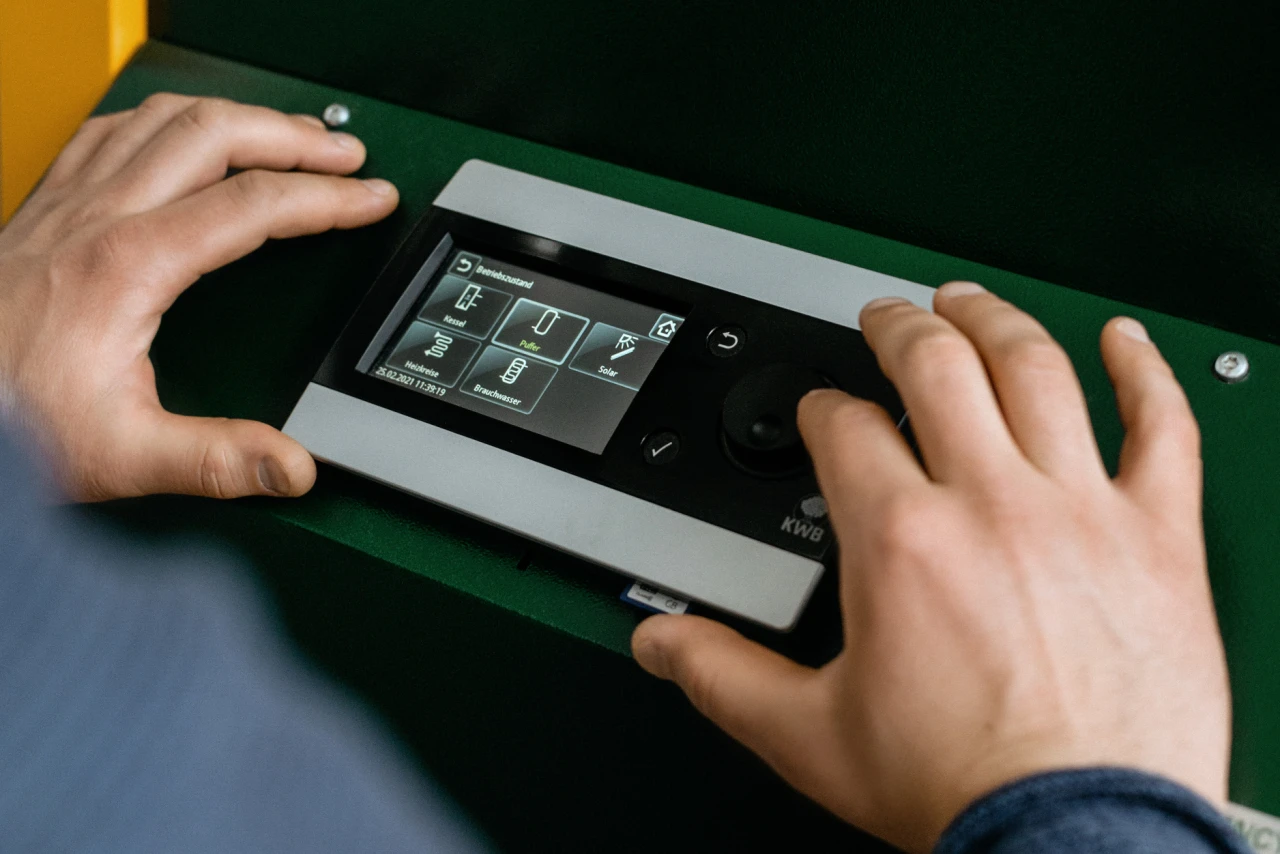 Referenzkunde Gregor Reicher | © KWB, LupiSpuma Hier sieht man wie Herr Reicher am Bedienungsgeraet des KWB Multifire etwas einstellt