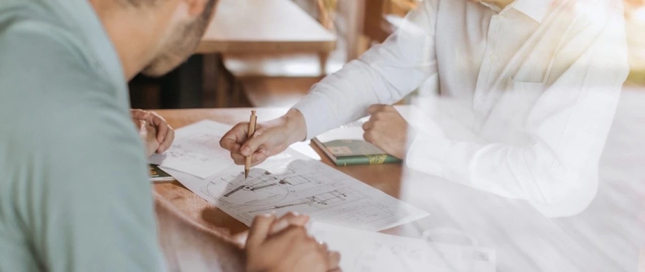 Bauplan | © KWB, LupiSpuma Ein KWB Mitarbeiter erklaert einen Kunden einen Plan fuer die Heizung