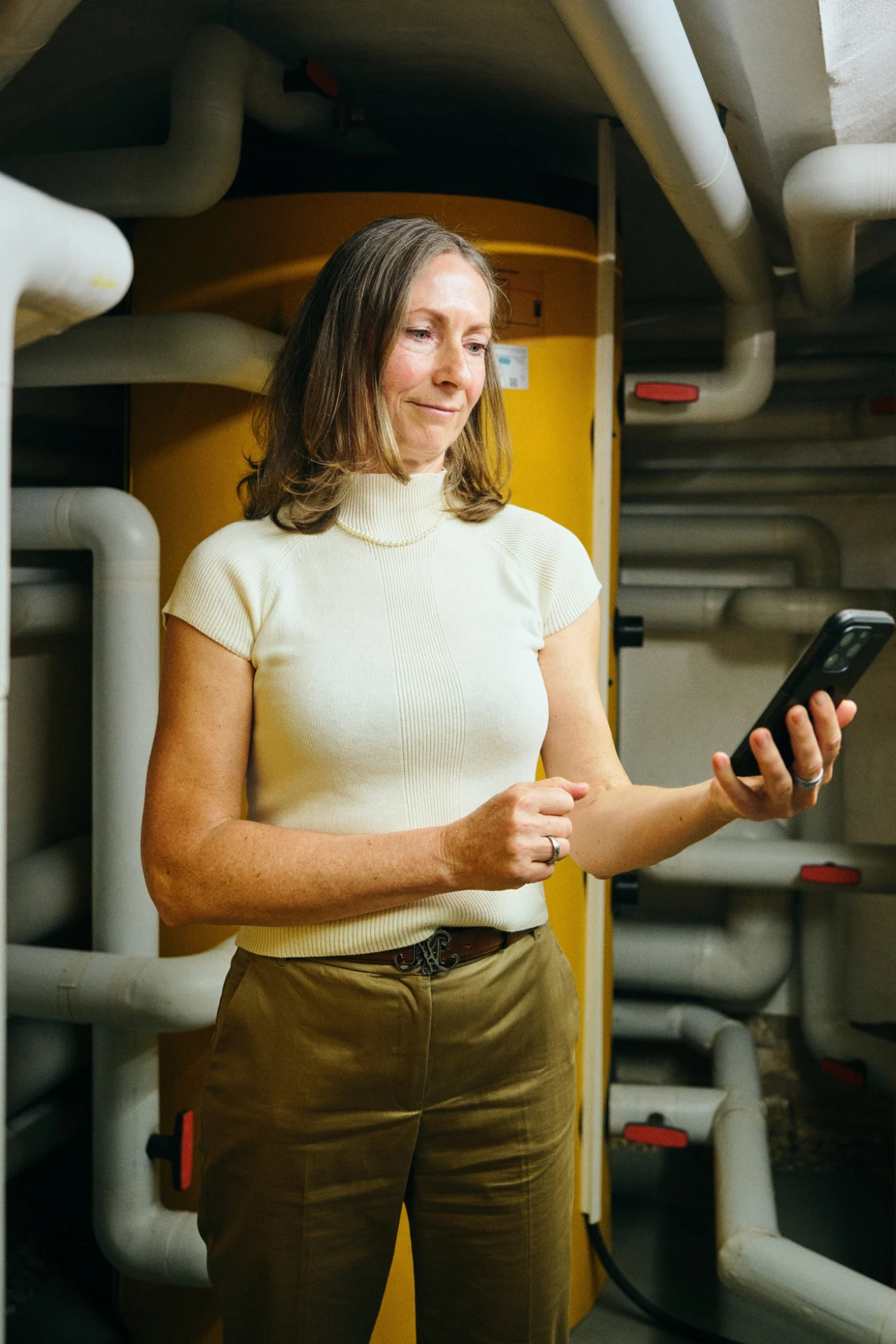 Referenzkunde Antje Krause | © KWB, Raphael Nast Man sieht eine Frau in einem Raum mit Ihrem Handy