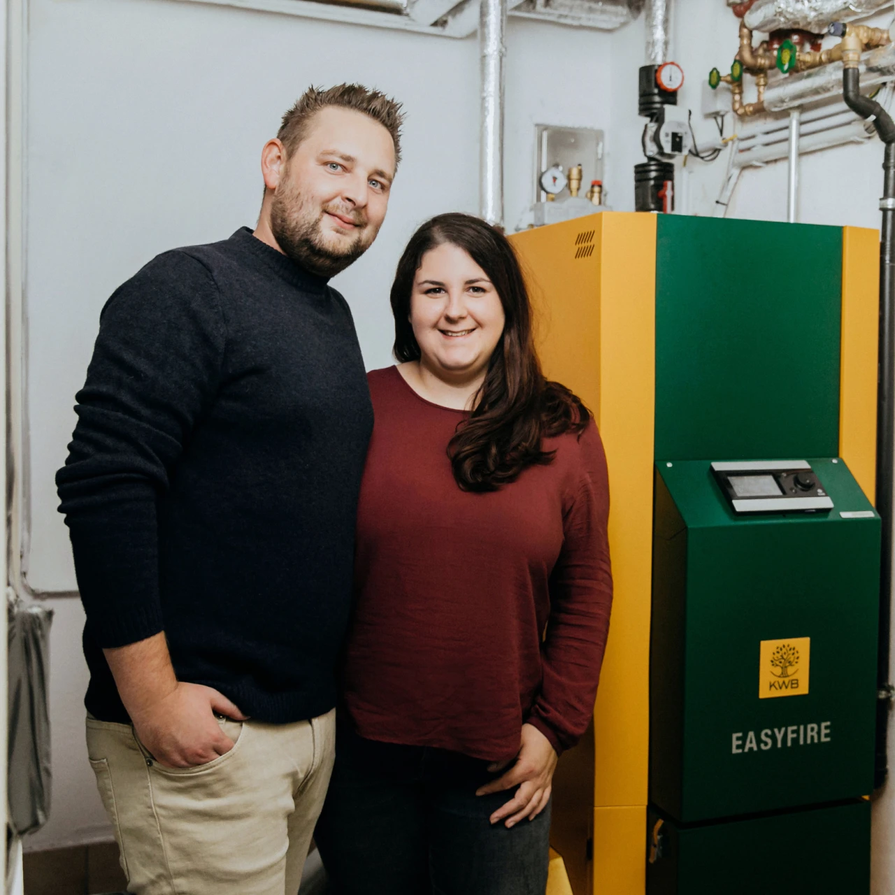 Referenzkunde Familie Hartmann | © KWB, LupiSpuma Hier sieht man die Familie Hartmann wie sie vor dem KWB Easyfire Kessel stehen