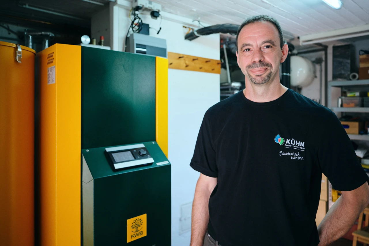 Referenzkunde SHK Kühn KWB Easyfire | © KWB, Raphael Nast Hier sieht man einen Mitarbeiter von Kuehn neben einem KWB Easyfire Kessel
