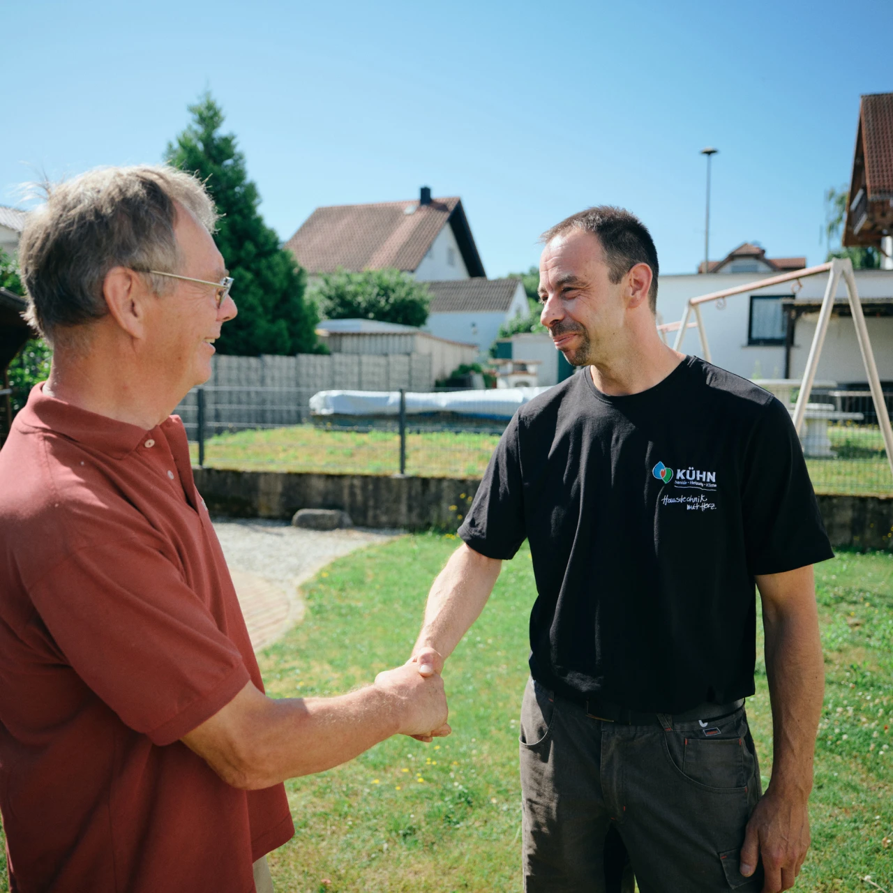 Referenzkunde SHK Kühn | © KWB, Raphael Nast Ein Mitarbeiter von Kuehn schuettelt die Hand vom Kunden im Garten