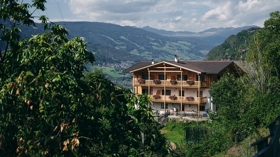 Am Gschlunerhof, einem typischen Südtiroler Bergbauernhof, beschäftigt man sich mit Viehhaltung, Acker- und Obstanbau. Ruhesuchende können hier aber auch einen authentischen Urlaub am Bauernhof erleben. Umgeben von Wäldern und Wiesen konkurriert die Schönheit der Natur mit dem architektonischen Charme des Bauerngehöfts im traditionellen Stil. Die Natur und Althergebrachtes zu bewahren, ist den Besitzern ein grosses Anliegen. Aus diesem Grund haben sie beim Um- und teilweise Neubau ihres Bauernhofs darauf geachtet, dass natürliche Rohstoffe und Materialien verwendet wurden. „Unser Haus wurde komplett aus Holz erbaut“, erzählt Arthur Mauroner voller Stolz. Alle Räume wurden mit Zirbenholz aus den umliegenden Wäldern ausgestattet. 